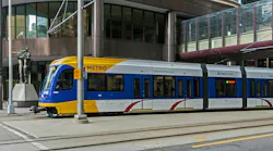 The image shows a Metro Transit light-rail train roll down the track.