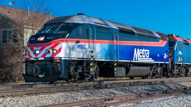 The image shows a Metra train moving along the track.
