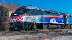 The image shows a Metra train moving along the track. The image shows a Metra train moving along the track.
