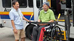 An operator helps a wheelchair users off an accessible bus.