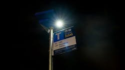 A solar light is shown mounted atop a bus stop pole. A solar light is shown mounted atop a bus stop pole.