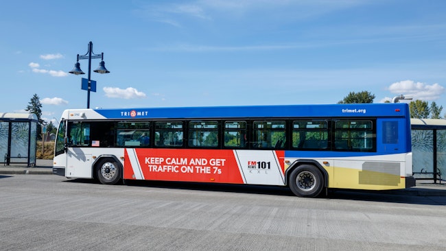 A TriMet bus approaches a stop.