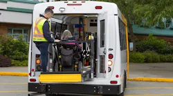 A HandyDART operator assists a rider entering into a vehicles.