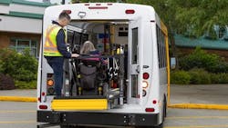 A HandyDART operator assists a rider entering into a vehicles. A HandyDART operator assists a rider entering into a vehicles.