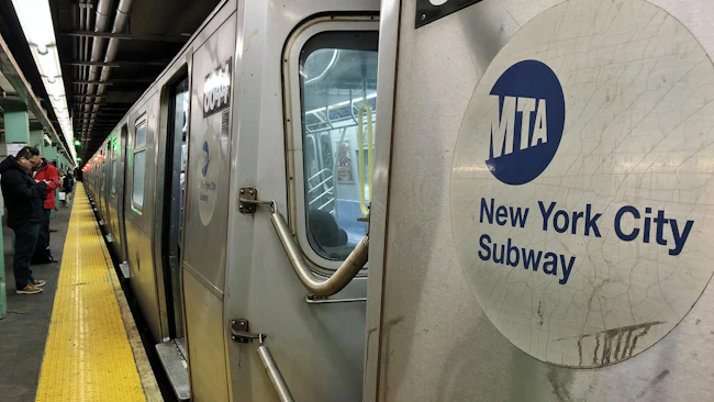 The image shows an MTA Subway logo on the side of a subway car.