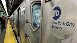 The image shows an MTA Subway logo on the side of a subway car. The image shows an MTA Subway logo on the side of a subway car.