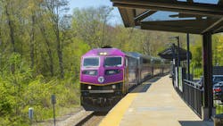 An MBTA commuter train stops at a station. An MBTA commuter train stops at a station.