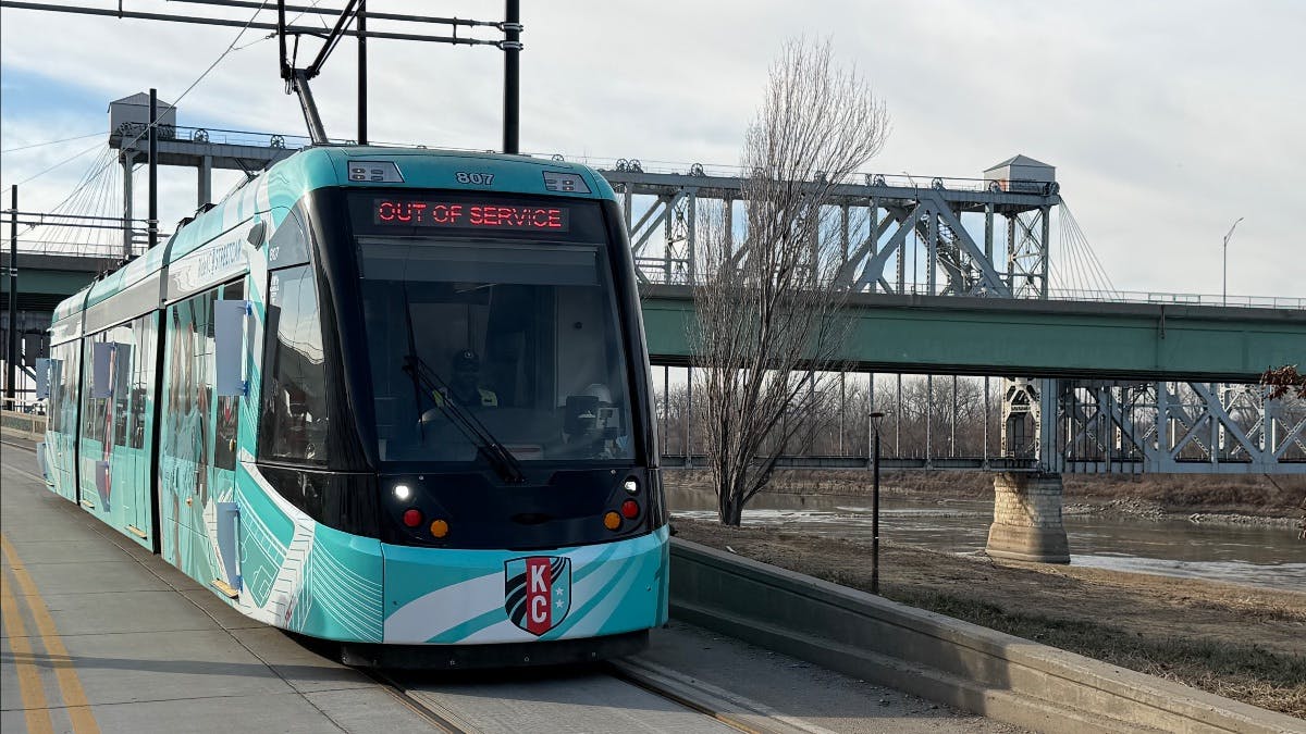 A new streetcar moves down the track.