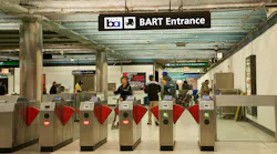 Entrance fare gates to Powell Street BART Station with people in station