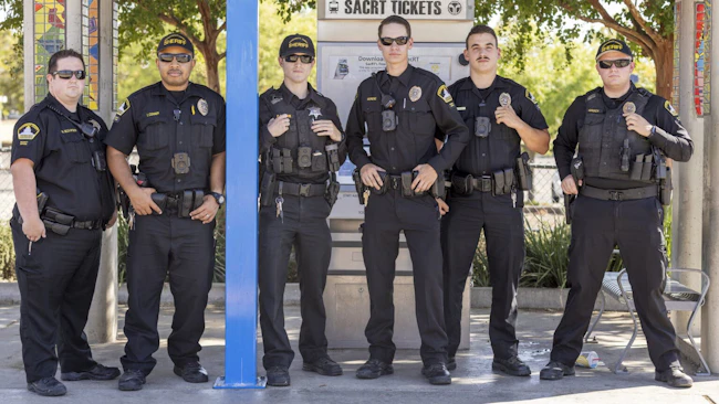 Officers that will patrol SacRT transit services stand in front of a ticket vending area.