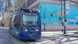 A streetcar moves down the track through the city. A streetcar moves down the track through the city.