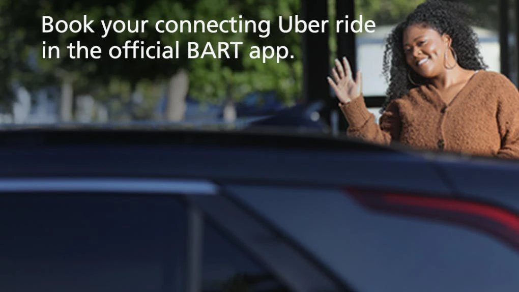 A passenger waves at her ridershare driver as she approaches the car ...