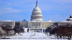 The image shows the U.S. Capitol covered in snow.