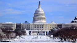 The image shows the U.S. Capitol covered in snow. The image shows the U.S. Capitol covered in snow.