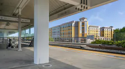 The image shows an exterior shot of the new building taken from a nearby transit platform.