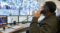 man on telephone in front of computer safety monitors in control room man on telephone in front of computer safety monitors in control room