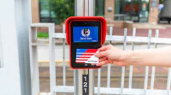 A hand taps a fare card to a reader.