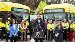 King County Metro leaders stand in front of the new buses parked angled in behind them. King County Metro leaders stand in front of the new buses parked angled in behind them.