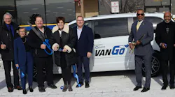 Pace and Metra leaders stand in front of a VanGo van with jumbo scissors.