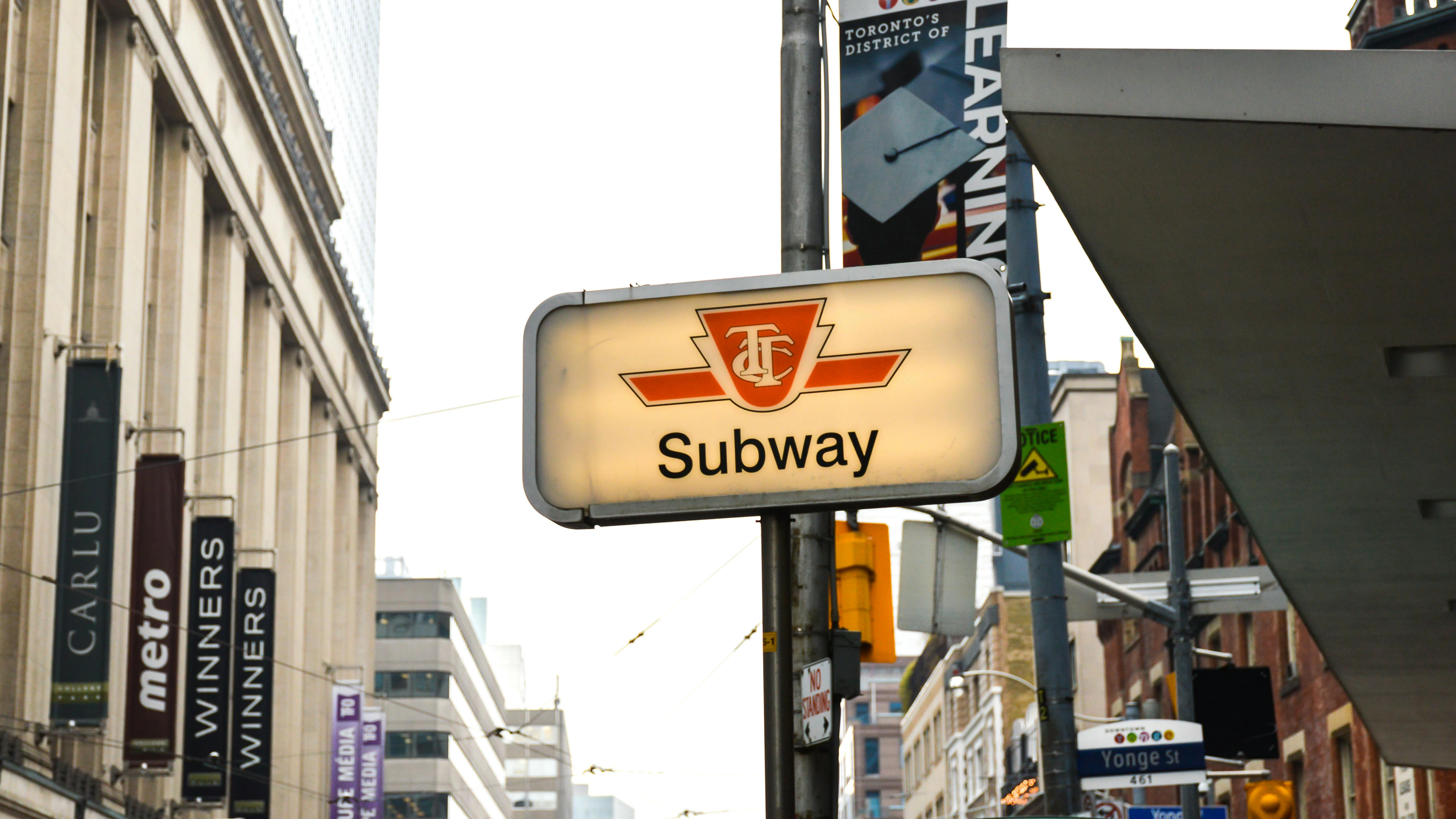 A TTC subway sign rests on a pole.