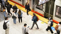 Riders use cell phones on the platform as they wait for a train. Riders use cell phones on the platform as they wait for a train.