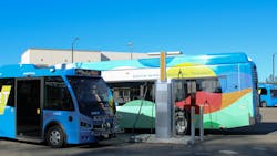 A bus and a paratransit vehicle charge in the outdoor SMRT yard. A bus and a paratransit vehicle charge in the outdoor SMRT yard.