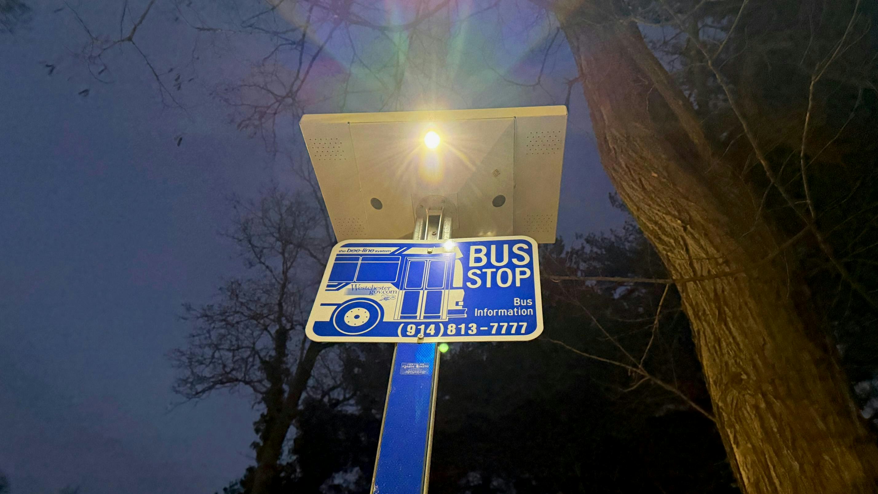 A solar light illuminates a Westchester County bus stop sign.