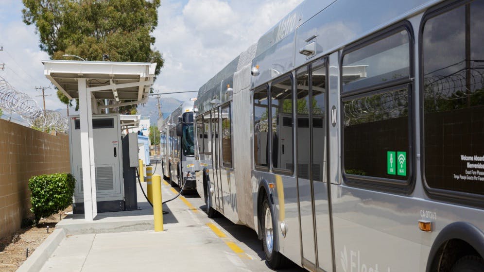 An L.A. Metro bus sits plugged into a charger.