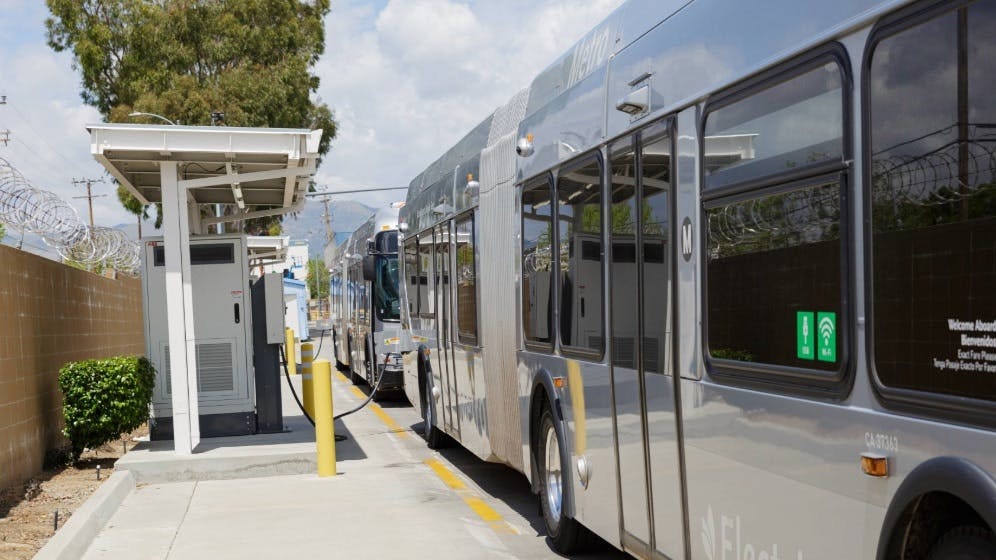 An L.A. Metro bus sits plugged into a charger.