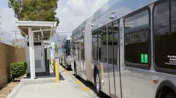 An L.A. Metro bus sits plugged into a charger.