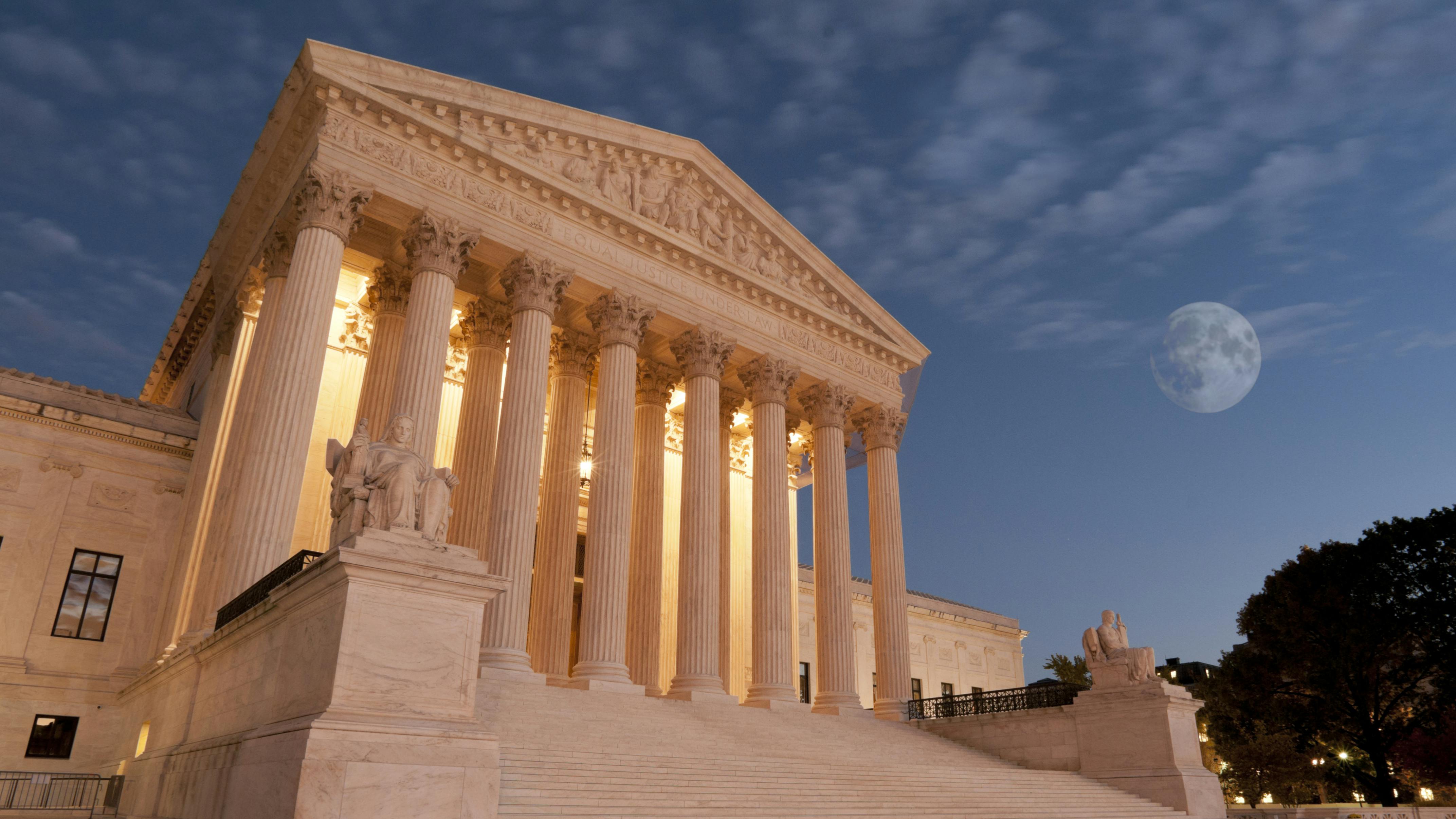 The image shows the U.S. Supreme Court building in the evening.