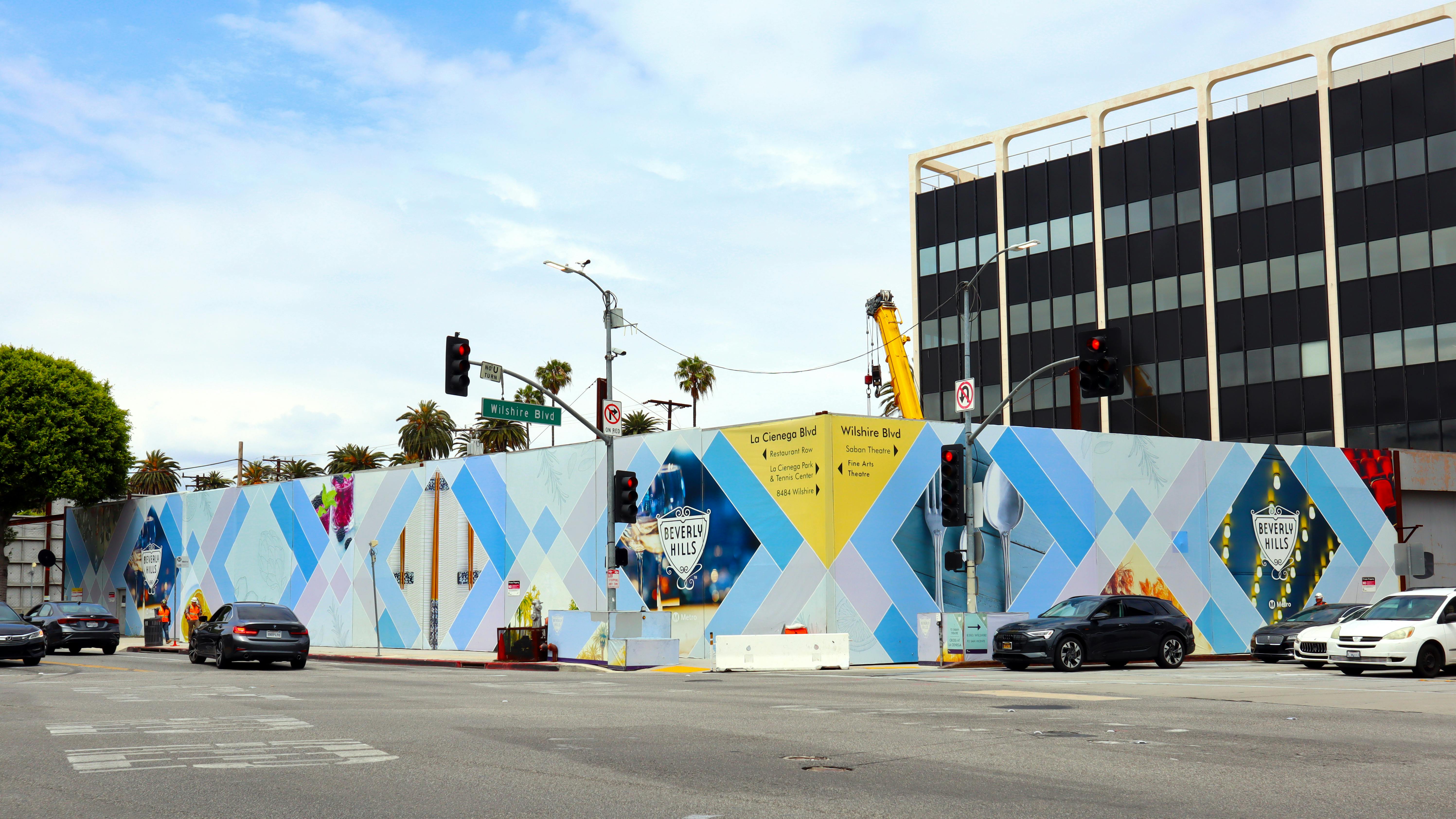 The image shows temporary walls construction areas for the D Line extension project in Beverly Hills.