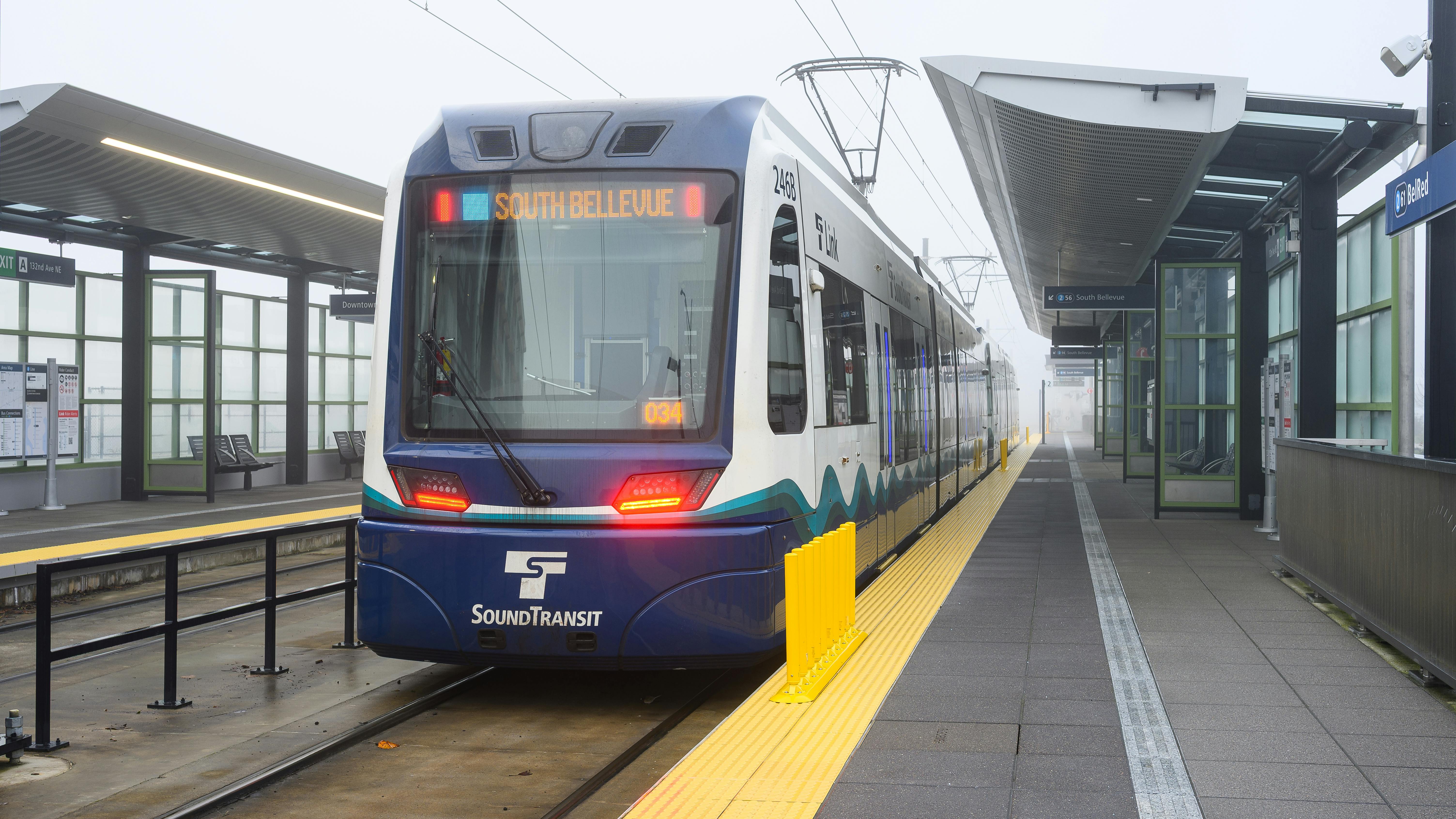 A Sound Transit rail vehicle pulls away from a station.