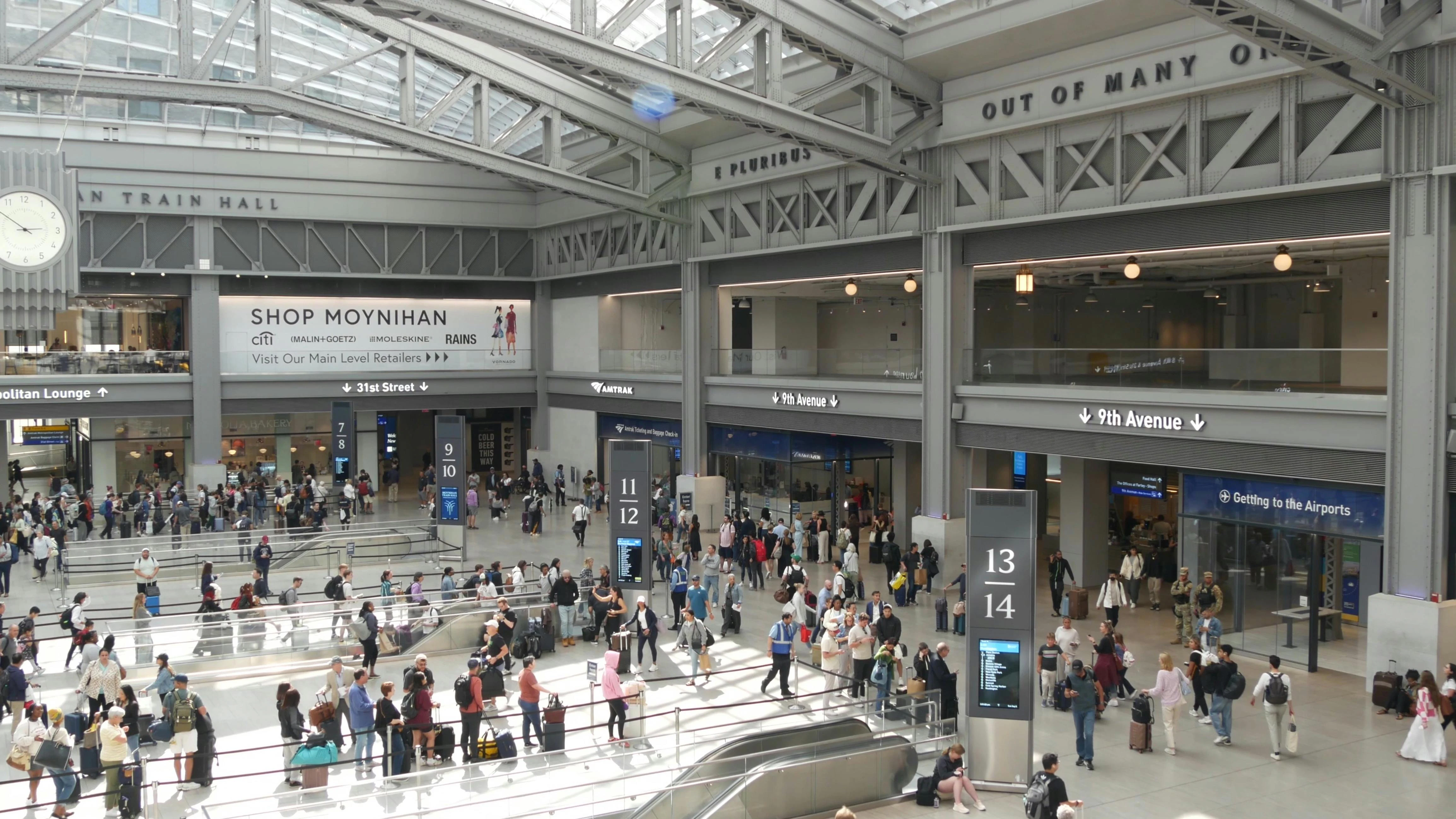 Passengers mill about Moynihan Train Hall.