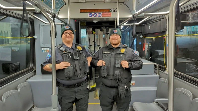 Two ABQ Ride TSOs stand inside a bus.