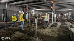 =An MBTA construction crew discusses work in a tunnel near signaling equipment. =An MBTA construction crew discusses work in a tunnel near signaling equipment.