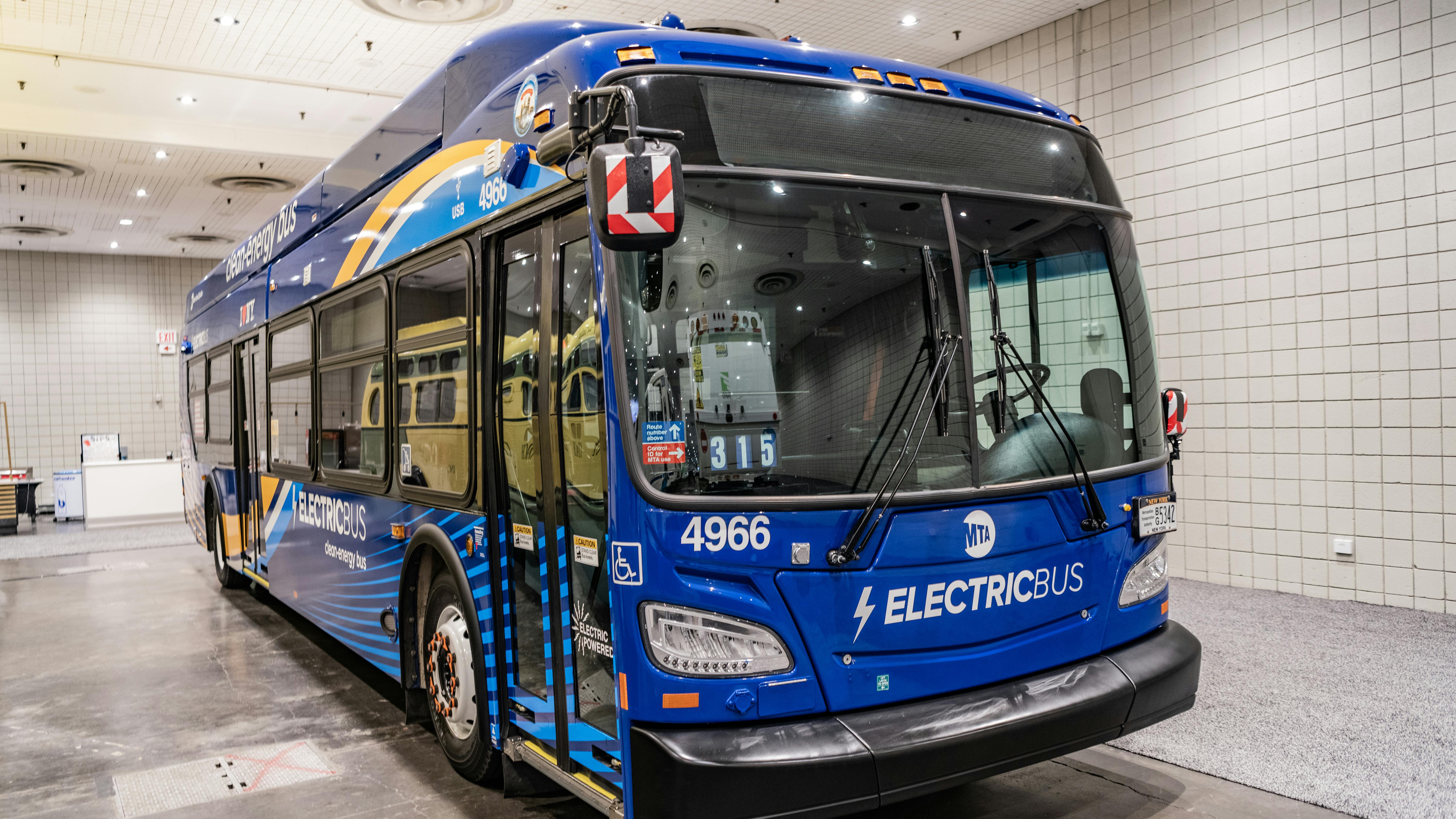 An electric MTA bus sits parked at a depot.