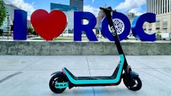 A Veo scooter sits parked in front of a I heart ROC sign. A Veo scooter sits parked in front of a I heart ROC sign.