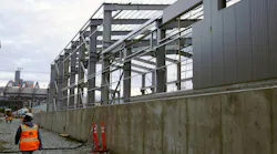 A construction worker walks alongside the new structure.