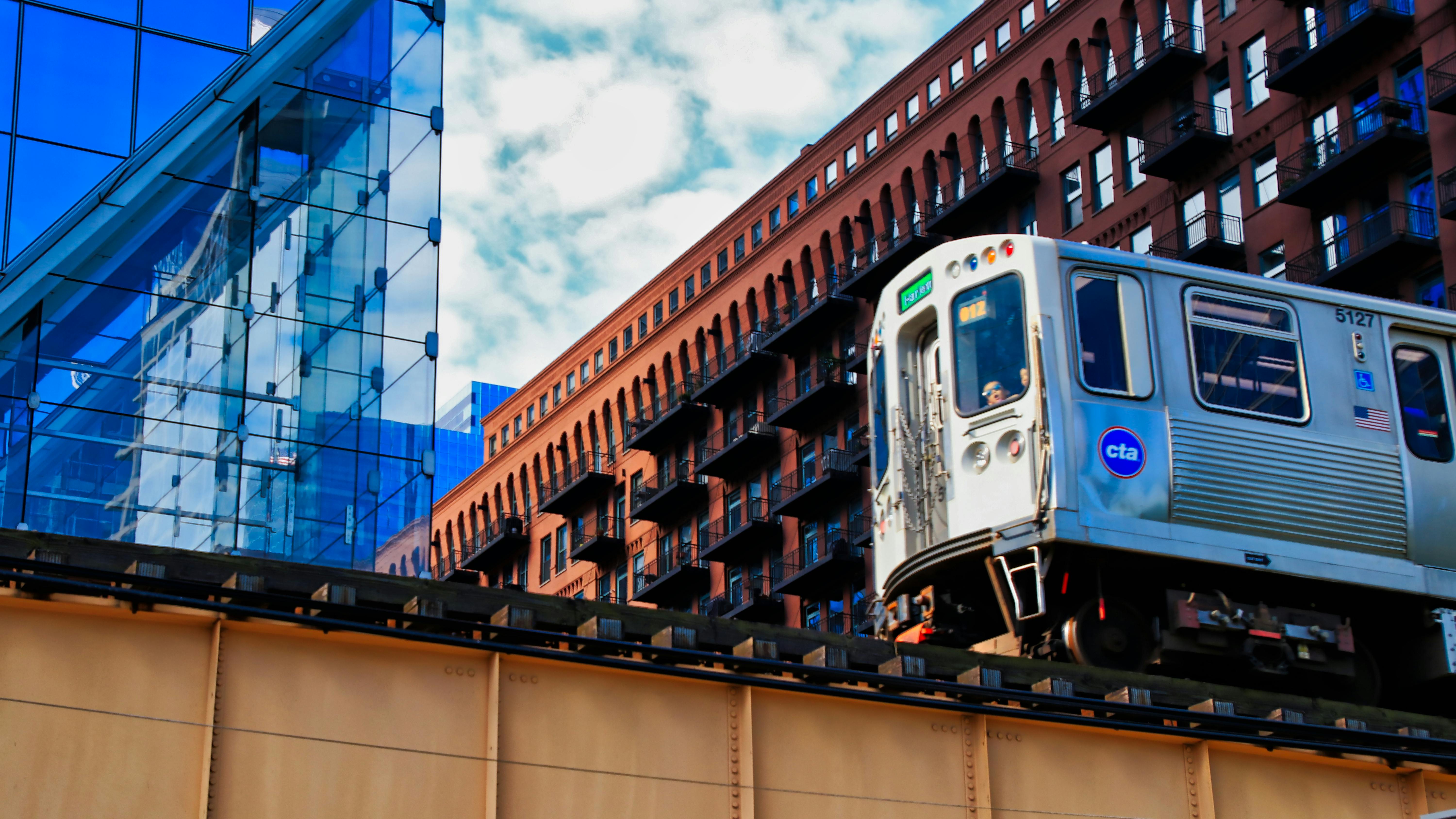 A CTA train is pictured from a lower angle moving along an elevated track.