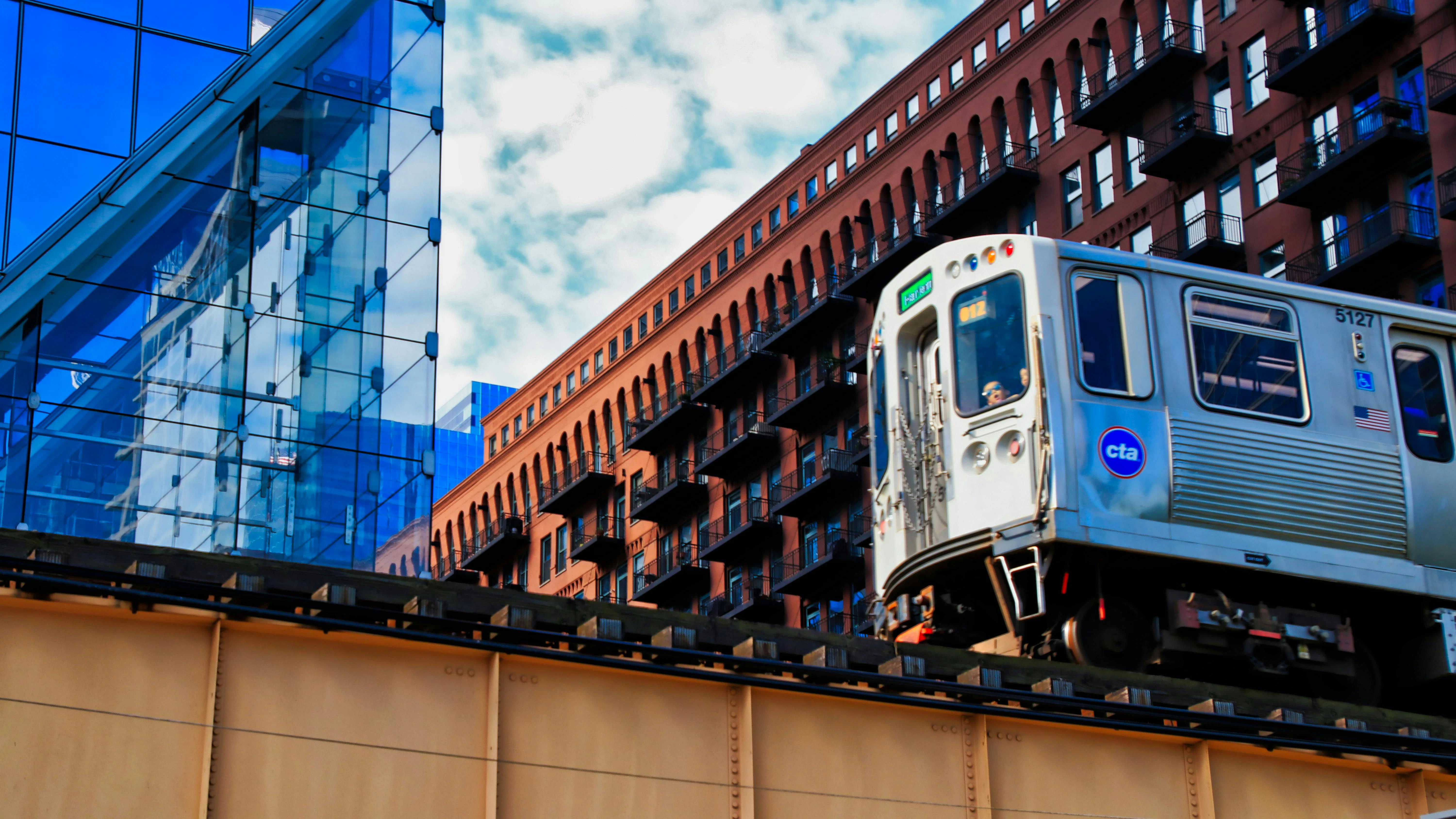 A CTA train is pictured from a lower angle moving along an elevated track.