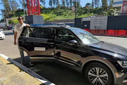 A SilverRide driver holding a door of a vehicle. A SilverRide driver holding a door of a vehicle.