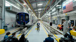 The image shows a wide shot of MTA CEO Jano Lieber speaking to event attendees from a lectern.