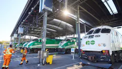 Workers in high-vis gear speak outside of GO Express trains. Workers in high-vis gear speak outside of GO Express trains.