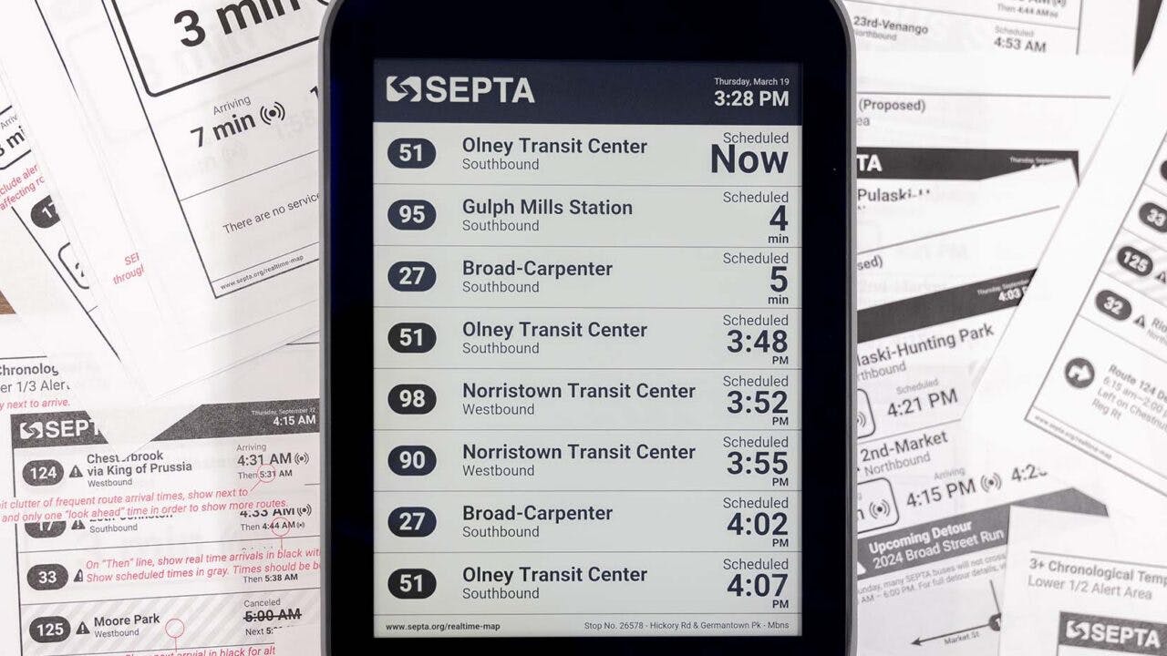 The image displays an e-paper display with transit times displayed.