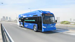 A New Flyer Xcelsior CNG compressed natural gas transit bus rendered in a promotional image, traveling on an elevated highway with a blurred urban skyline in the background. The bus features a bold blue and black livery with a fragmented geometric graphic pattern along the side and the text 'Welcome to cleaner, smarter mobility.' The destination sign reads 'XCELSIOR CNG' and the New Flyer logo is visible on the front fascia. Compressed natural gas storage tanks are visible on the roof. A New Flyer Xcelsior CNG compressed natural gas transit bus rendered in a promotional image, traveling on an elevated highway with a blurred urban skyline in the background. The bus features a bold blue and black livery with a fragmented geometric graphic pattern along the side and the text 'Welcome to cleaner, smarter mobility.' The destination sign reads 'XCELSIOR CNG' and the New Flyer logo is visible on the front fascia. Compressed natural gas storage tanks are visible on the roof.