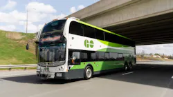 A GO Transit double-decker bus travels along a highway beneath an overpass. The destination sign reads 'Welcome to GO Transit.' The bus features the agency's white and green livery with the GO logo on its upper front panel. A GO Transit double-decker bus travels along a highway beneath an overpass. The destination sign reads 'Welcome to GO Transit.' The bus features the agency's white and green livery with the GO logo on its upper front panel.