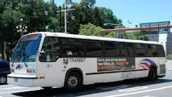 A New Jersey Transit bus with advertising on its side driving along Washington Street. A New Jersey Transit bus with advertising on its side driving along Washington Street.