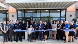 A large group of officials and community members pose for a ribbon-cutting ceremony outside a Metropolitan Transit Authority of Harris County (METRO) facility at 7003 Harrisburg Blvd. Participants hold a blue ribbon printed with the METRO logo. A person using a wheelchair is centered in the front row among the group, which includes uniformed police officers and suited officials. A large group of officials and community members pose for a ribbon-cutting ceremony outside a Metropolitan Transit Authority of Harris County (METRO) facility at 7003 Harrisburg Blvd. Participants hold a blue ribbon printed with the METRO logo. A person using a wheelchair is centered in the front row among the group, which includes uniformed police officers and suited officials.