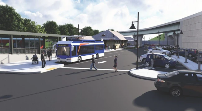 An architectural rendering of a transit hub showing a blue-and-white bus marked 'Not In Service' pulling through a passenger drop-off area. A historic station building with a peaked roof sits in the background, flanked by a modern covered bus shelter on the left and a parking lot on the right. Pedestrians and a wheelchair user are depicted on the sidewalk.